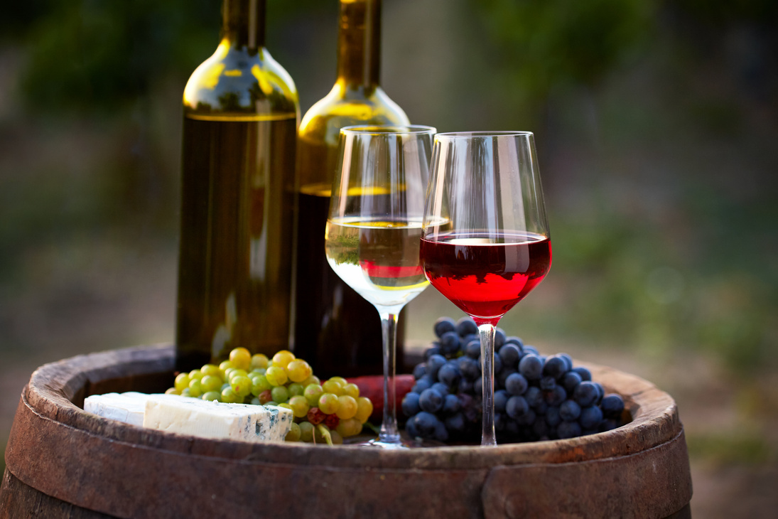 Pair of Wine Glasses and Bottles on Old Barrel