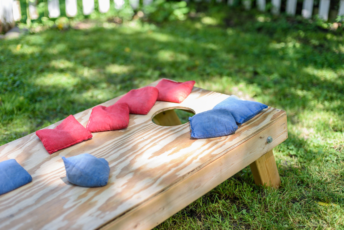 Homemade corn hole game board in backyard sunlight